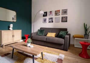 Un salon moderne avec un canapé, une table basse et des fauteuils d’une couleur rouge vive.