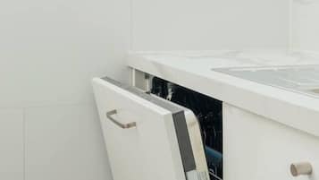A kitchen with white cabinets and a dishwasher.