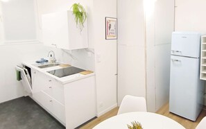 Eine moderne Küche mit weißen Schränken, einem eingebauten Herd und einem Kühlschrank.