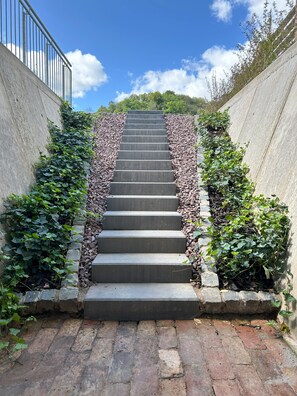 Eine Betonstufenhaus mit Steinabstufungen und -wänden, umgeben von Grünpflanzen.