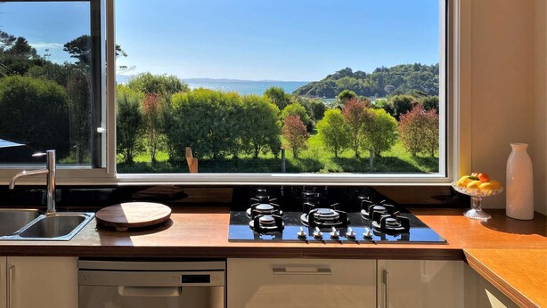 Une cuisine dotée d’une grande fenêtre donnant sur un paysage magnifique.
