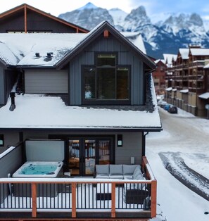 A two-story chalet with a balcony and a hot tub. - Tamarack Steamside Deluxe Chalet - Private Hot Tub (Canmore)