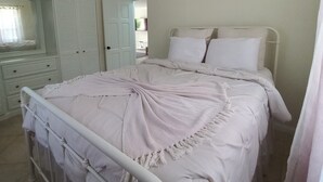 A bedroom with a bed, a wardrobe, and a mirror. - Idyllic serene secure condo minutes from beach & amenities.  (Bridgetown)
