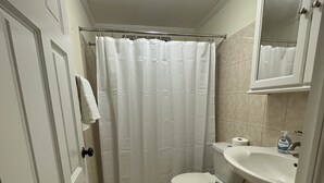 A bathroom with a toilet, sink, and shower curtain. - Idyllic serene secure condo minutes from beach & amenities.  (Bridgetown)