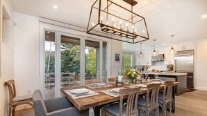 A modern kitchen with a dining area, large windows, and a chandelier. - Abode at Sugar Magnolia, outdoor living, private hot tub, Jackson (Jackson)