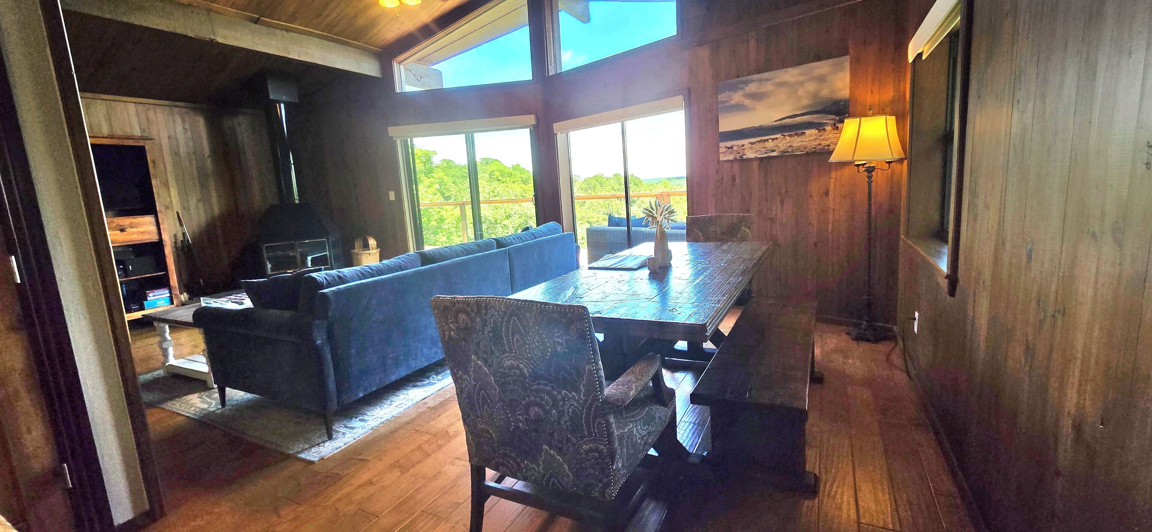 A room with a sofa, dining table, chairs, and a fireplace.