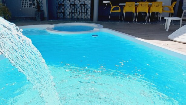 A swimming pool with a water feature. - Casa Paraíso das Conchas (Barra de São Miguel)