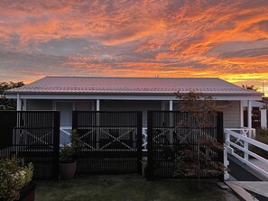 A house with a metal roof, a fenced backyard, and a white railing on a staircase. - Spacious sunny cottage (airport close, family, pet friendly, disability access) (Christchurch)