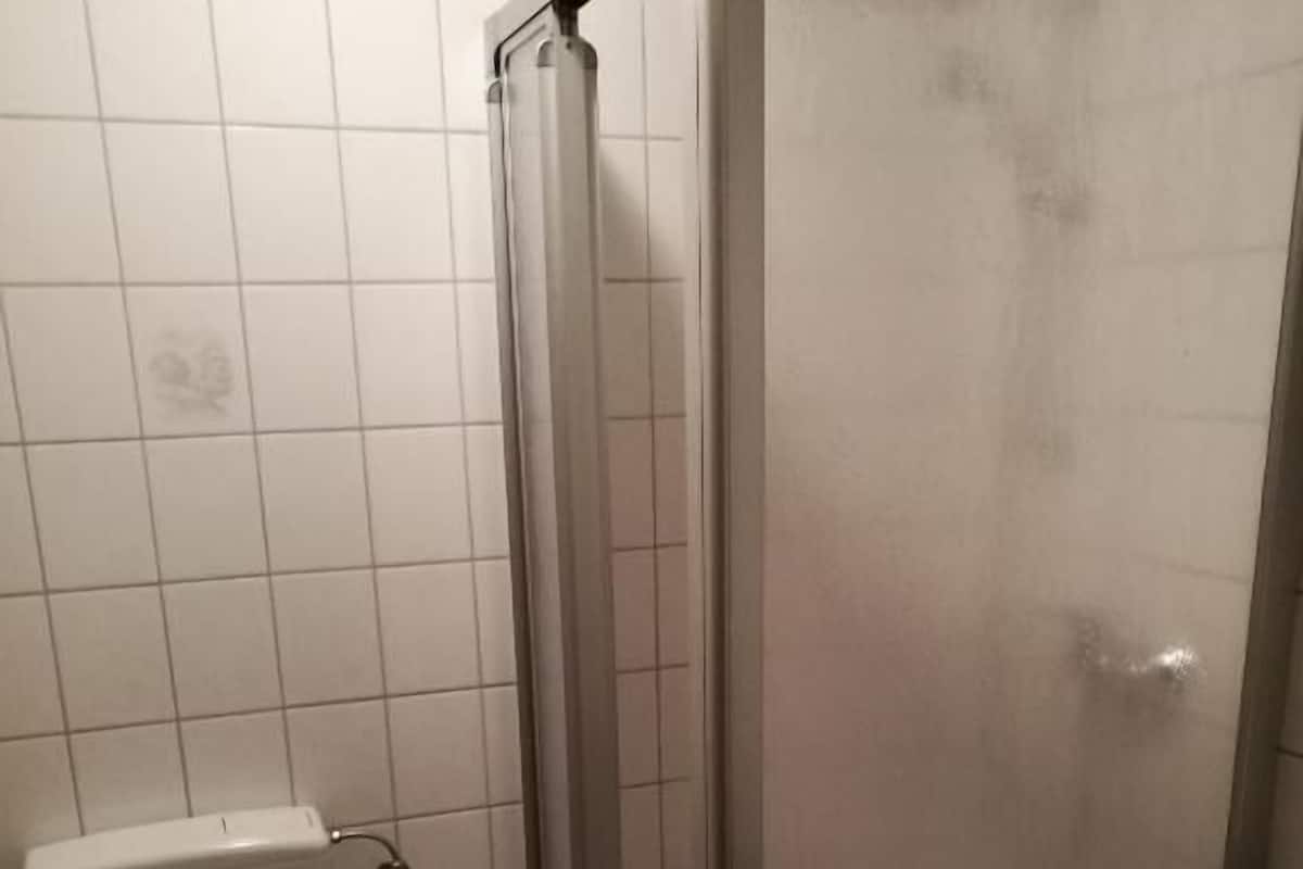 Uma casa de banho com sanita, cabine de duche e lavatório.