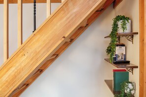 A wooden staircase with a book titled "WONDERLAND" by Lewis Carroll on the top shelf. - New Hot Tub - Sweet Pines Cabin - Sleeps up to 8 (Patriot)