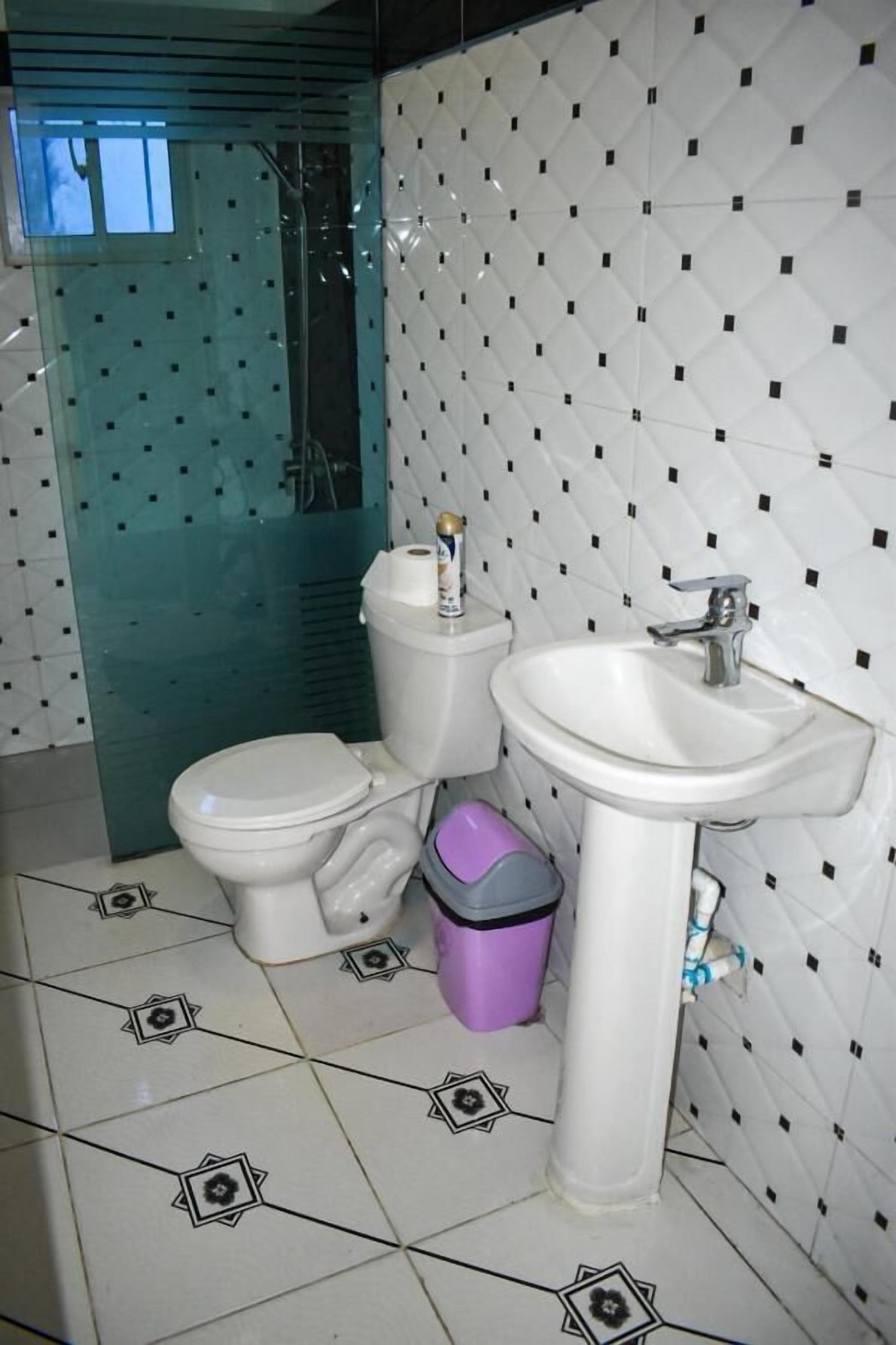A bathroom with a toilet, sink, and shower.