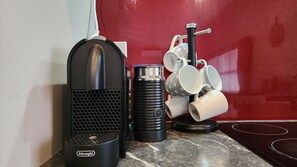 A coffee machine, a thermos, and a mug rack in a kitchen area.