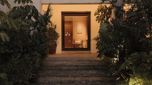 L’entrée d’un hôtel, avec une enseigne indiquant « CASA OFELIA » et un escalier menant à la porte.