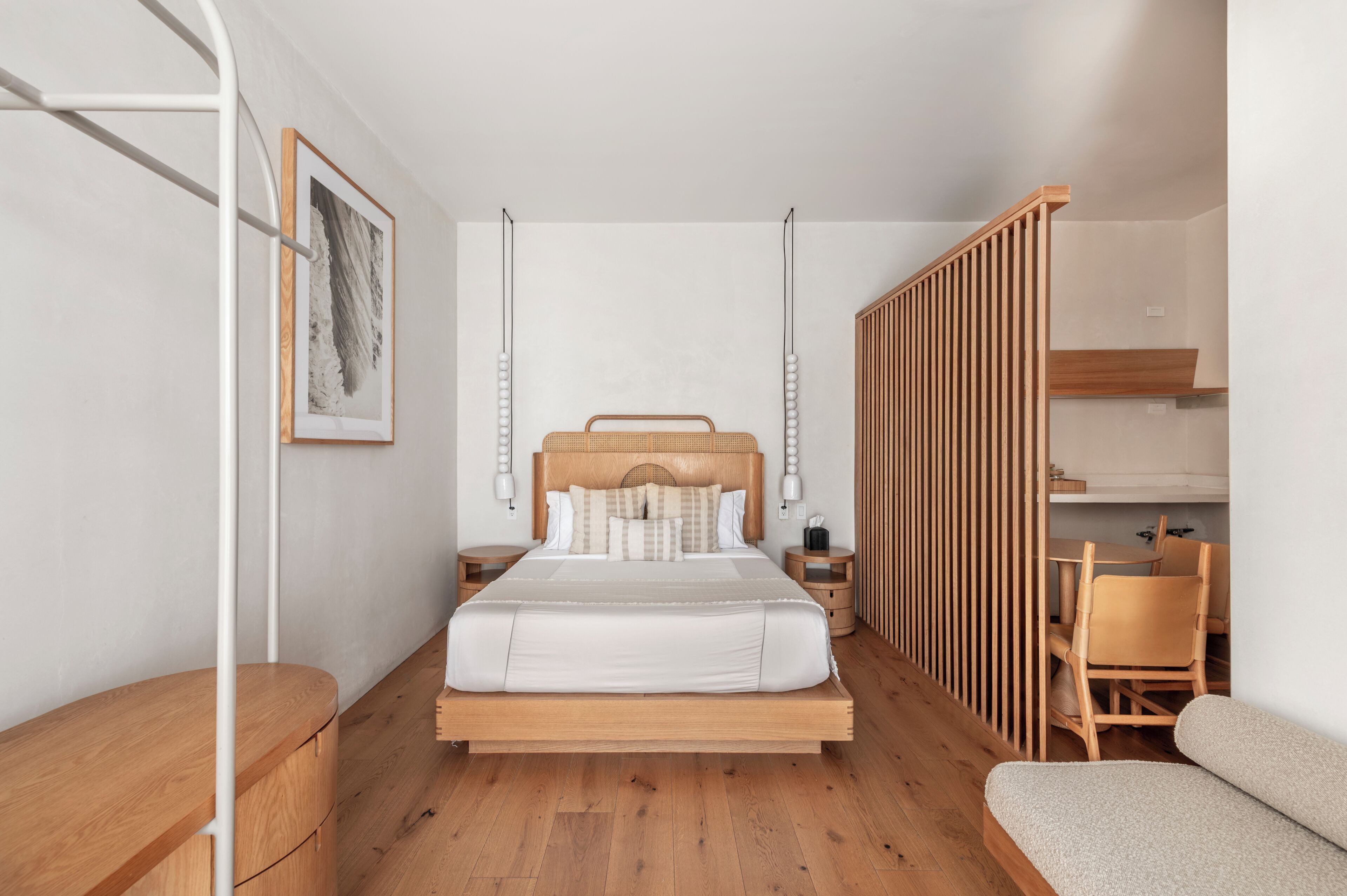 A modern bedroom with a wooden bed, bedside tables, a wooden chair, and a desk.