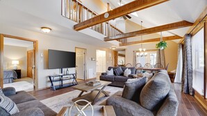 A spacious living room with a large sofa set, a coffee table, and a flat-screen TV mounted on the wall. - Welcome to our Pocono Cottage (Tobyhanna)