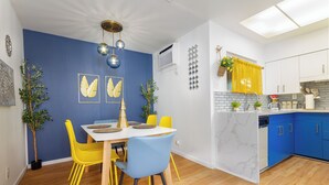 A modern kitchen with blue cabinets, a white island, and yellow chairs. - Retro River House! Waterfront, Firepit, BBQ, Gameroom, 1 min to Sequoia Park.  (Three Rivers)