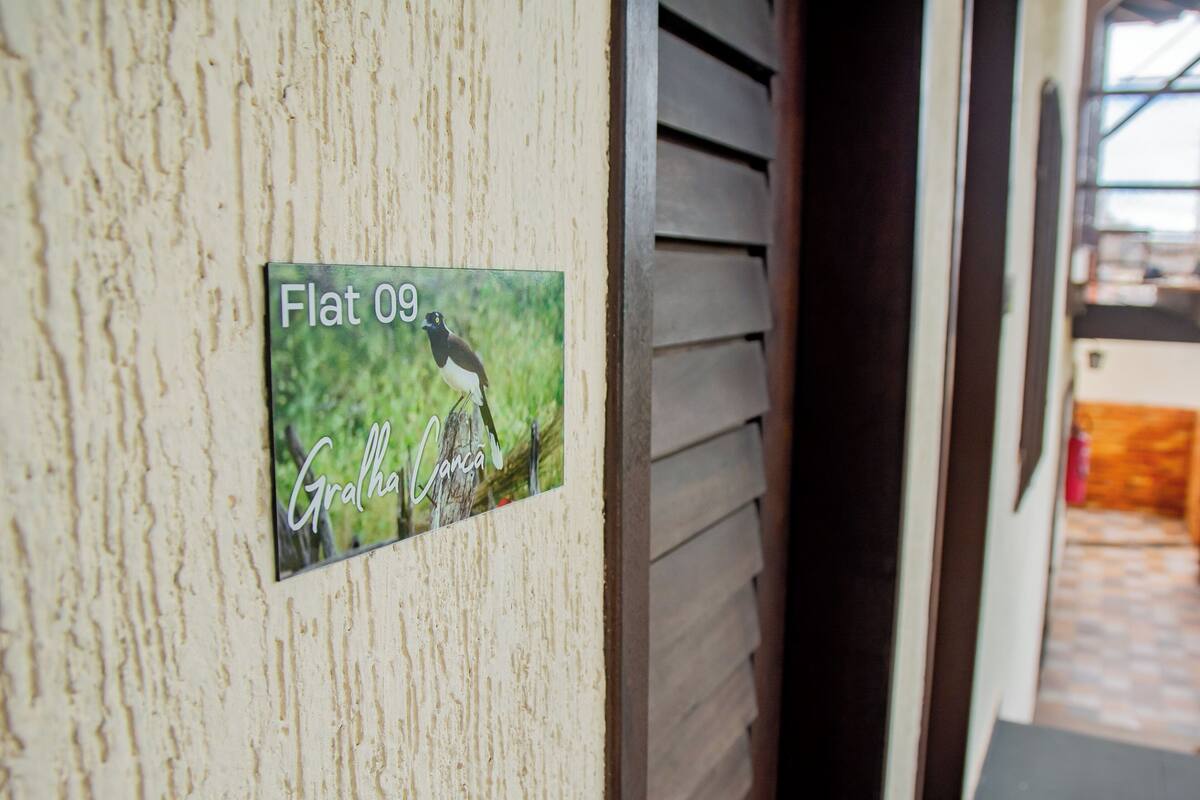 A sign with a bird and the text "Flat 09" and "Gralha Canela".