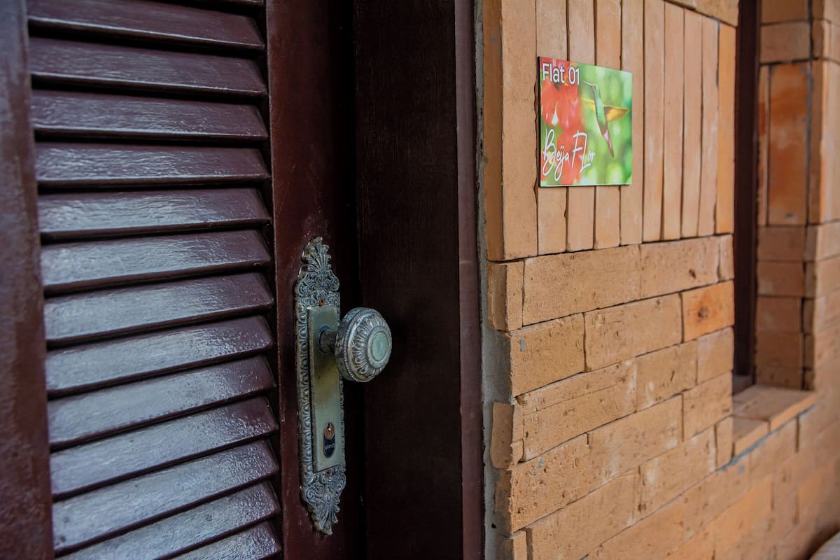 A wooden door with a metal handle and a sign on the wall.