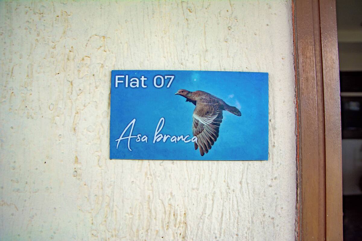 A sign with a bird and text on a wall.