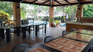 An outdoor patio with a pool, covered seating area, and a bar. - La Joya del Lago (Chapala)