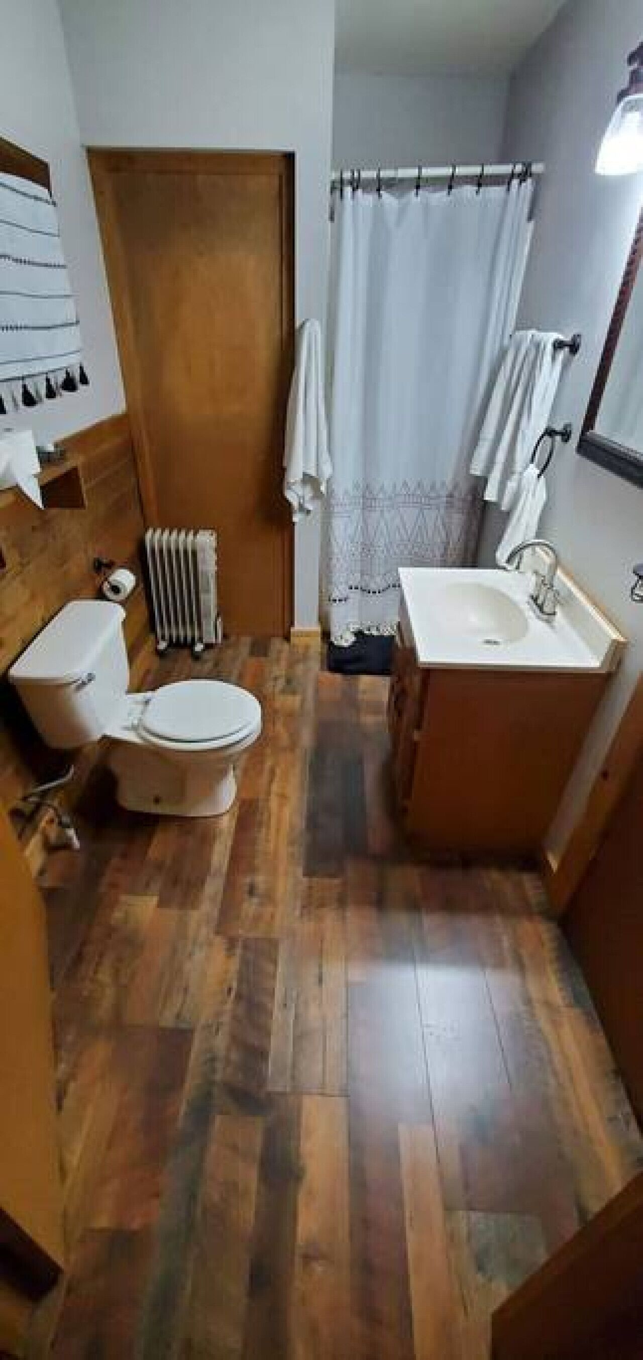 Un baño pequeño con inodoro, lavamanos y zona de ducha.