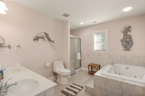 A bathroom with a toilet, sink, shower, and bathtub.