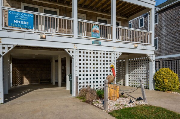 A two-story building with a covered entrance and a sign for Coastal Carolina Vacations.