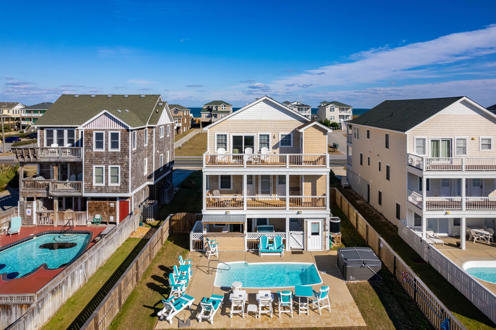 A residential complex with multiple two-story buildings, a swimming pool, and outdoor seating areas.