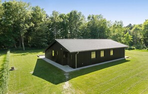 Situated in a serene natural setting, this single-story building features a simple, functional design with large windows.