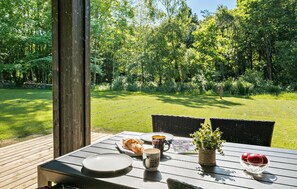 Enjoy a romantic meal under the shade of a wooden structure, surrounded by lush greenery.