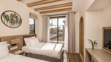 A hotel room with two beds, a wooden ceiling, a large window with curtains, a wall-mounted artwork, and a small table with a vase.