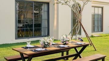 A picnic table set up on a lawn with a building in the background.