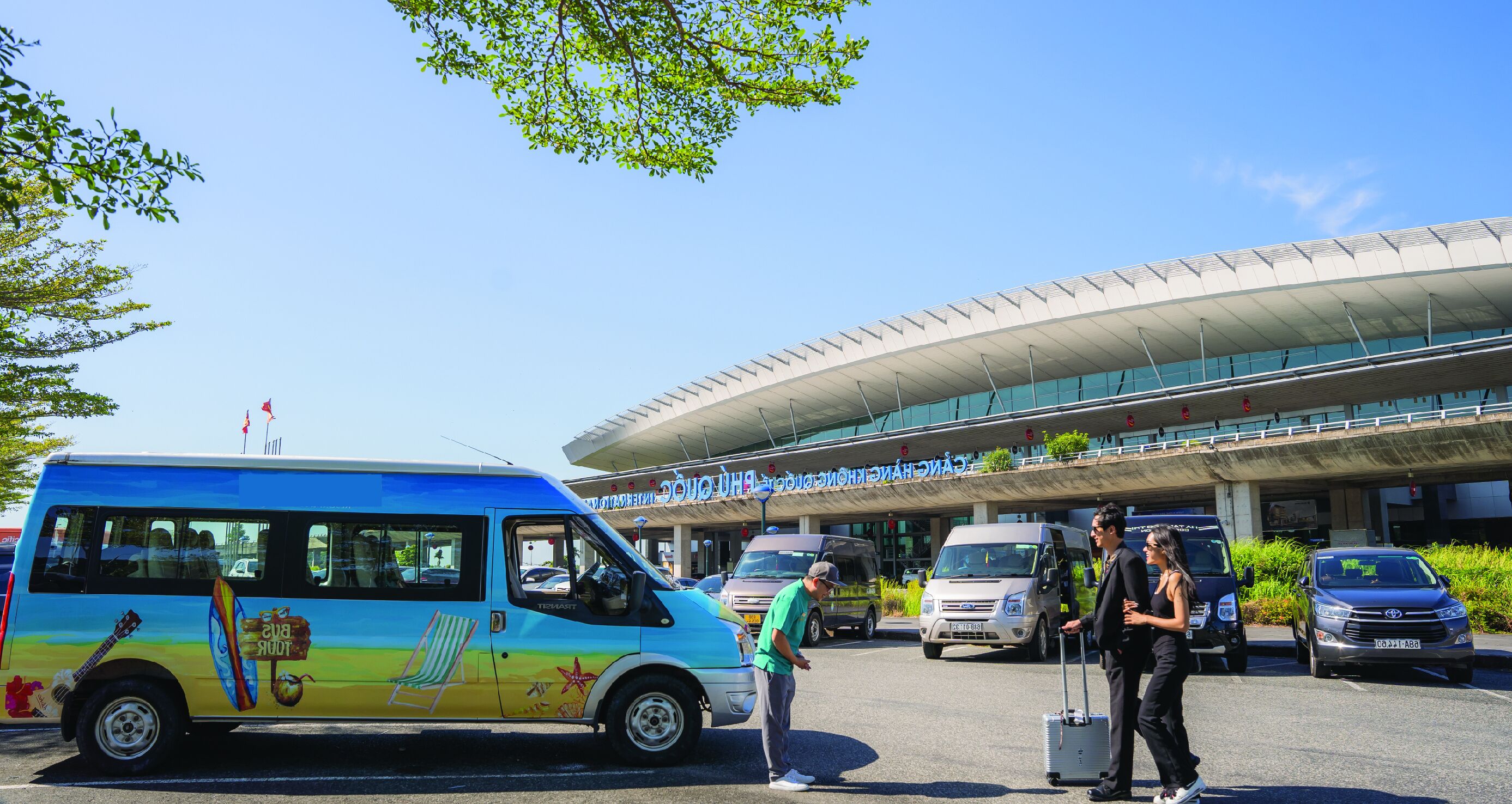 A colorful bus parked in front of a modern building with a curved roof and glass windows.