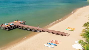 Una playa cerca, arena blanca, sillas reclinables de playa