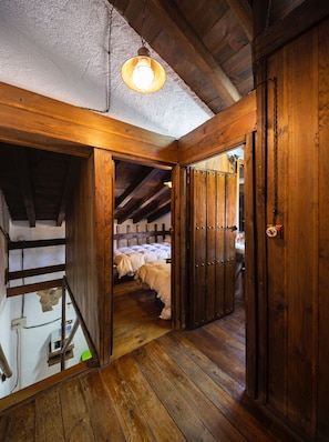Un intérieur en bois avec un escalier menant à une chambre dotée de deux lits.