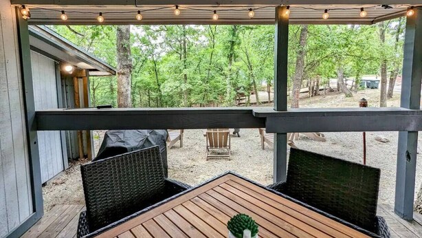An outdoor patio with wooden furniture and string lights. - Rustic Bungalow - Rugged with a Touch of Class (Sulphur)