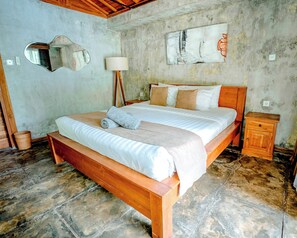 A bedroom with a wooden bed, a bedside table, a lamp, and a wall-mounted mirror.