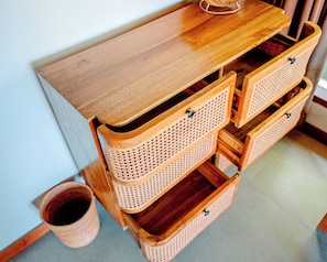 Een houten bureau met lades en een rieten mand.