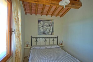 Cozy retreat with a single bed, painting of white flowers, and a ceiling fan.