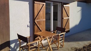 Un bâtiment moderne doté d’une terrasse en bois et d’une table avec des chaises.