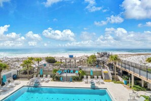A pool area with lounge chairs and a view of the beach. - Beachside One 4036 | DIRECTLY GULF FRONT! 2PM Check in!  3 BEDROOM, SLEEPS 10! Gorgeous Condo with amenities! (Miramar Beach)