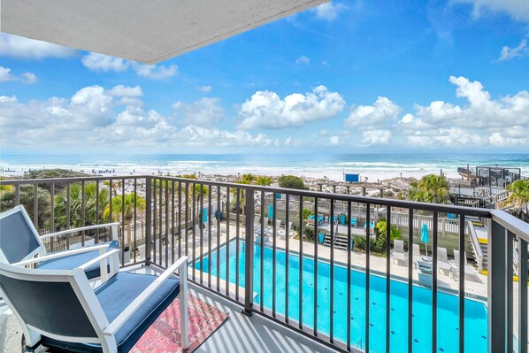 A balcony with a pool, overlooking a beach and ocean. - Beachside One 4036 | DIRECTLY GULF FRONT! 2PM Check in!  3 BEDROOM, SLEEPS 10! Gorgeous Condo with amenities! (Miramar Beach)