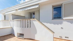 A modern two-story house with a balcony, a window with shutters, and a tiled patio. - Gioia 1 by Interhome (Marina di Pescoluse)