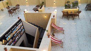 A hotel lobby with a staircase, seating areas, and a sign for daily tours. - DISCOVER Pyramids inn  (Giza)