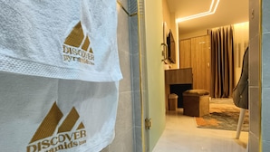 A hotel hallway with a white towel hanging on the wall, a wooden bench, and a modern interior design. - DISCOVER Pyramids inn  (Giza)