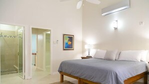 A bedroom with a bed, bedside table, lamp, and a painting on the wall. - Captivating 2-Bed Town-House in Kingston (Kingston)