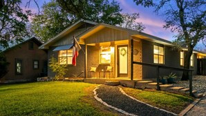 A house with a front porch, a flag, and a number '500' on the door. - 3 Bedroom Home / Hot Tub / Firepit / Game room (Fredericksburg)