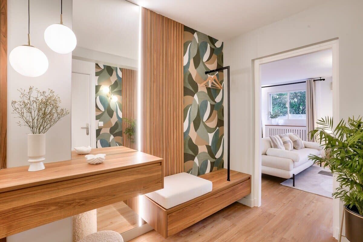 Un salon moderne avec un plancher en bois, un canapé blanc et une grande fenêtre.