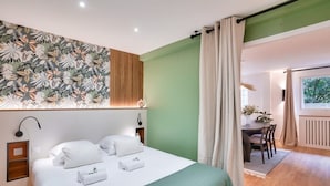 A hotel room with a bed, a desk, and a view of the outdoors. - Magnificent - 3 bedrooms - near Tour Eiffel (Paris)