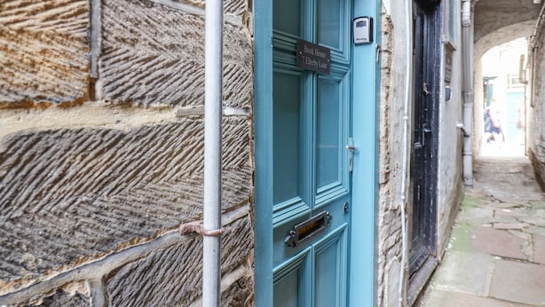 A blue door with a sign reading "Book House 7 ELLERY LANE". - Book House (Whitby)